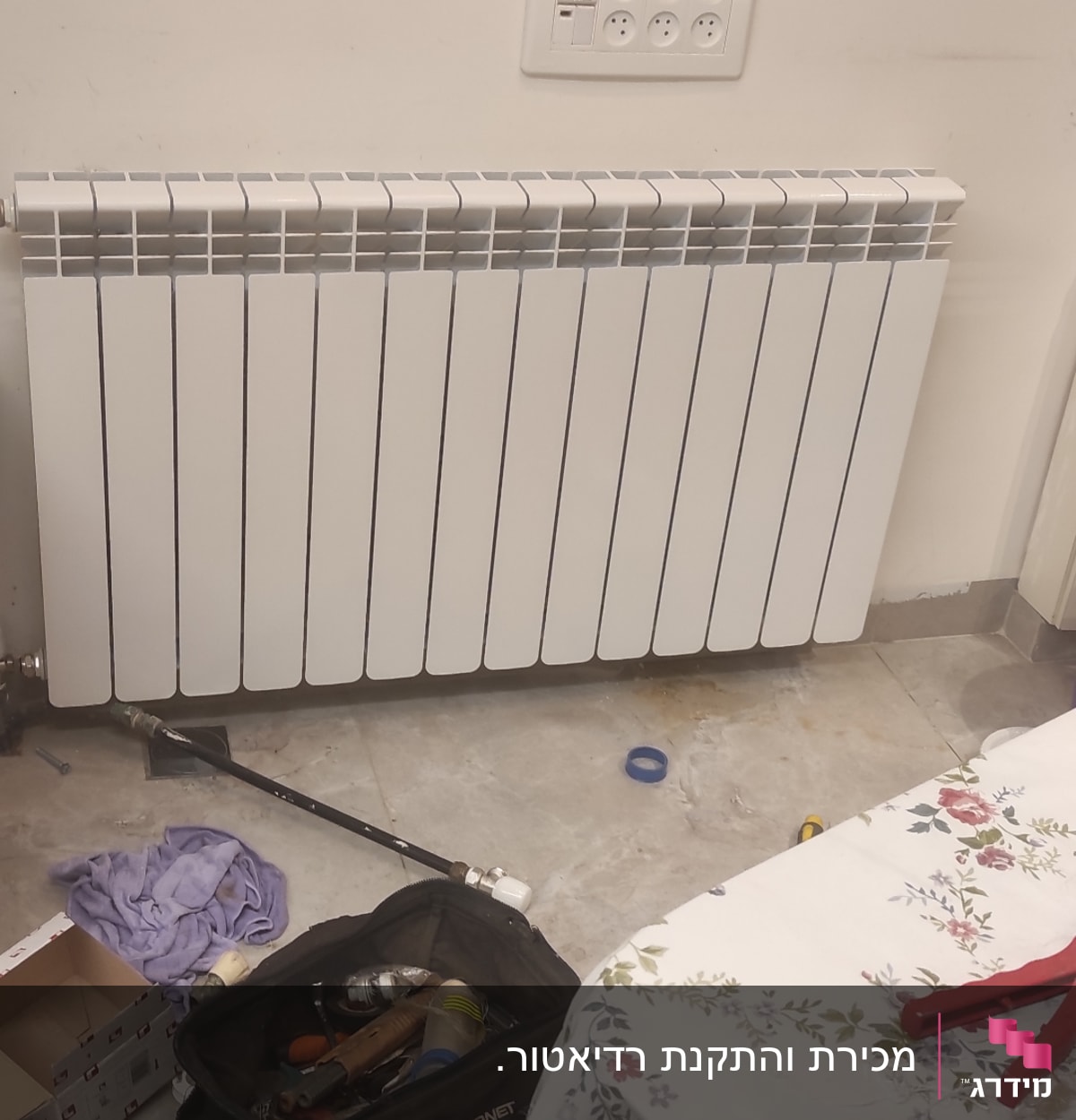 כלי עבודה של אינסטלטור ליד רדיאטור